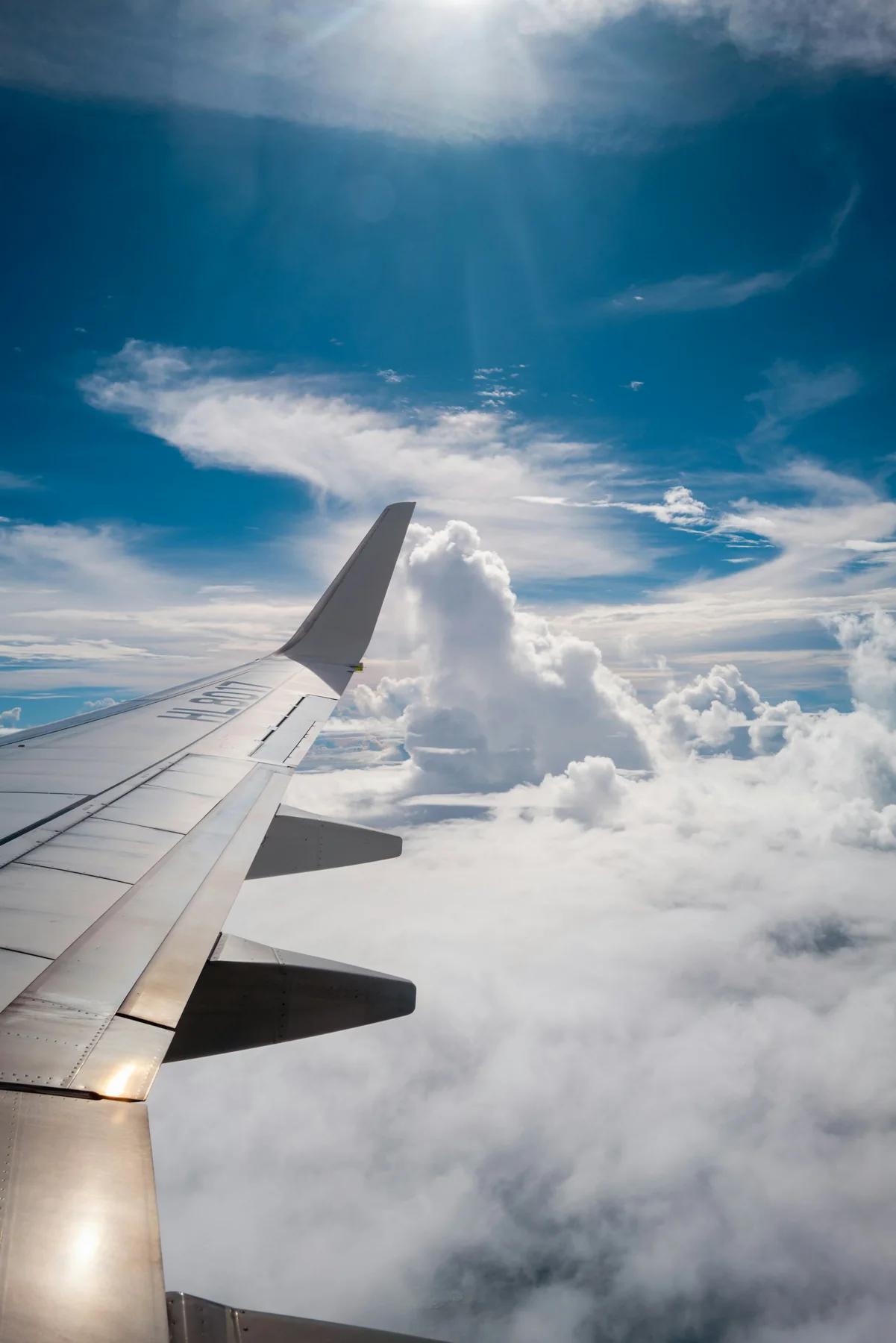 Aile d’avion au-dessus des nuages sous un ciel bleu